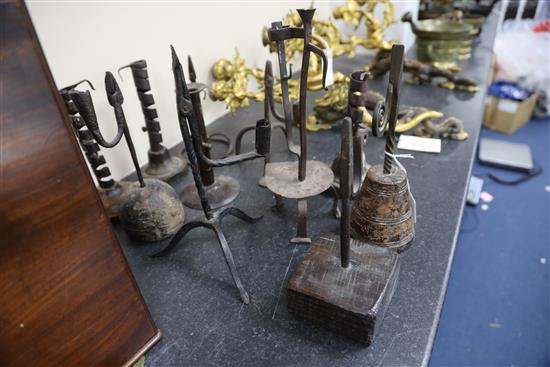 Eleven 17th century and later iron rushlight holders and candlesticks, largest 11.5in.